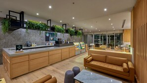 A modern interior with a central kitchen area, seating arrangements, and a coffee station. - City Express Plus by Marriott Guadalajara Providencia (Guadalajara)