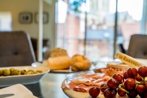 A table with various food items including olives, bread, and meats. - Stonegate Court (York)