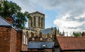 A historic church with a tall central tower and adjacent smaller buildings. - Stonegate Court (York)