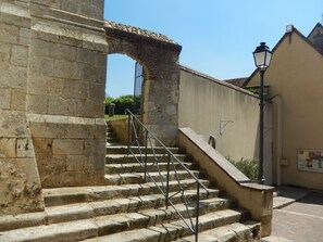 A stone staircase with metal railings leading to a gate, surrounded by stone walls and a lamp post. - Peacefull and greenery in the heart of Illiers Combray, Marcel Proust's village (Illiers-Combray)