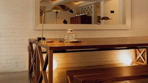 A modern kitchen with a wooden table, a bench, and a large mirror above the counter. - Casa Pani (Mexico City)