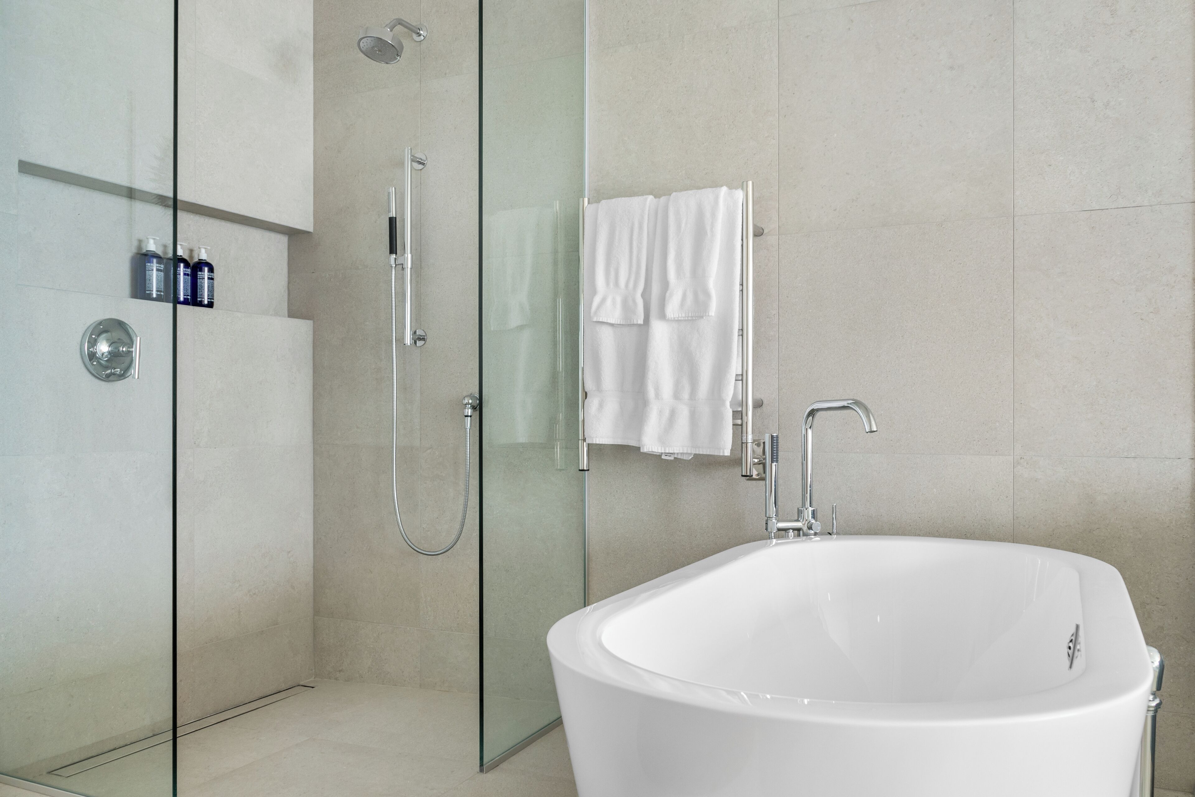 A modern bathroom with a freestanding bathtub, a glass-enclosed shower, and a glass shower door.