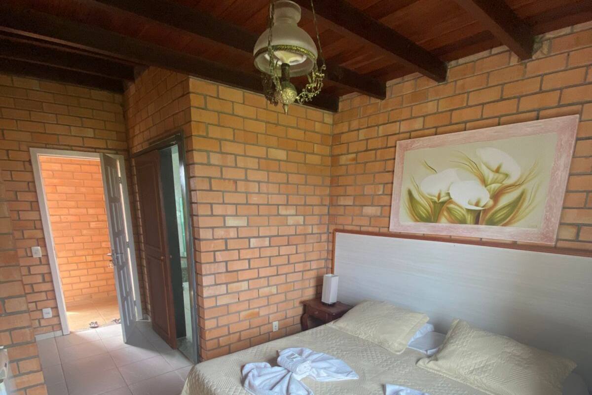 Ein Schlafzimmer mit einem Bett, einem Gemälde und einer Hängelampe.