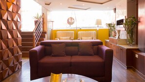 A modern interior with a sofa, a staircase, and a yellow wall. - Hotel Cusco Dreams (Cusco)
