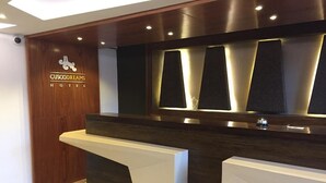 A reception desk with a wooden panel and a logo for CuscoDreams Hotel. - Hotel Cusco Dreams (Cusco)