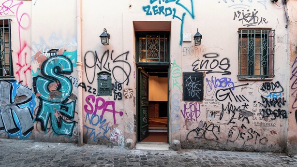 Un callejón con paredes llenas de grafitis y un empedrado.