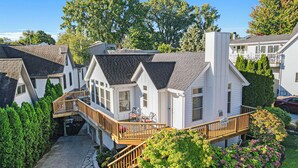 A row of white vacation homes with attached decks and a stone pathway. - "Let it B" Luxury lake home in South Haven MI. Just steps to N beach. Sleeps 8. (South Haven)
