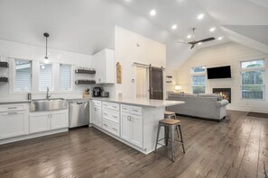 Enjoy a spacious kitchen with a large island, cozy living area with a fireplace, and a dining space with a bar stool.