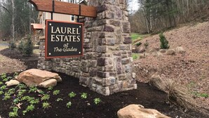 A stone and wood sign for Laurel Estates at The Glades.