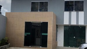 A building with a sign reading "Pousada São Miguel" and a modern entrance with glass doors. - Pousada São Miguel (Juazeiro do Norte)