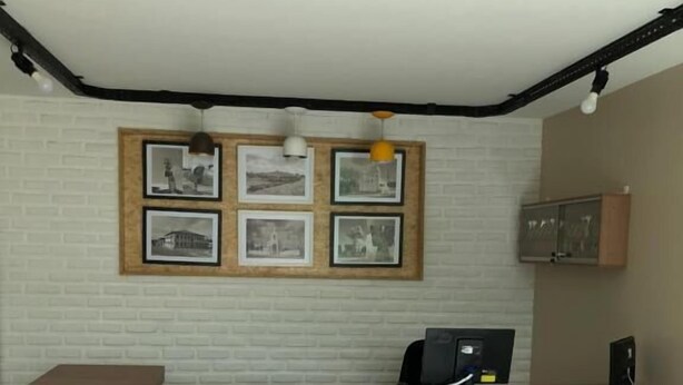A reception desk with a white brick wall, framed pictures, and a wooden counter. - Pousada São Miguel (Juazeiro do Norte)