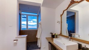 A modern bathroom with a large mirror, a white sink, and a window offering a view of the sky. - SUPER SEA VIEW PENTHOUSE (Rimini)