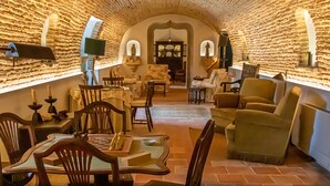 A cozy, stone-walled dining area with wooden furniture and a central table. - Quinta da Foz (Caldas da Rainha)