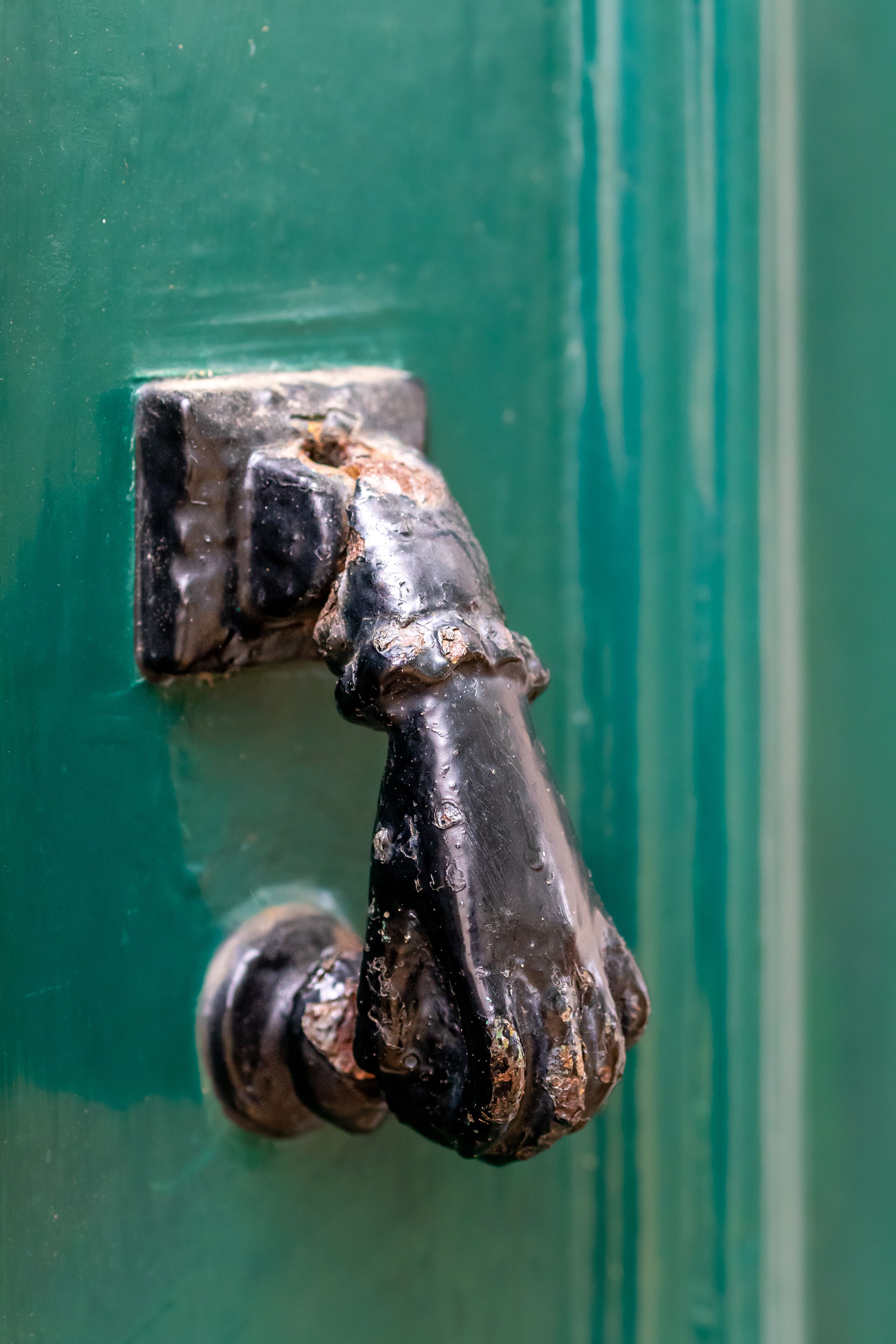 A close-up of a door handle with visible wear and rust.