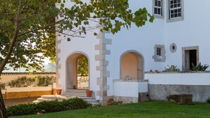 A white building with a garden, a stone staircase, and arched doorways. - Quinta da Foz (Caldas da Rainha)