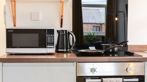 A compact kitchen with a microwave, kettle, stove, and oven. - Fulwood Heights (Preston)