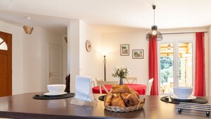 A dining area with a table set for two, a basket of bread, and a vase of flowers. - Wonderful private villa for 6 people with A/C, private pool, WIFI, TV and terrace (Lorgues)