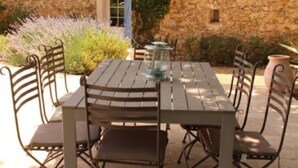 Eine Terrass mit Steinsicht, einem Tisch mit Stühlen und einem kleinen Brunnen.