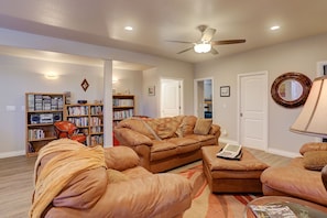 A living room with a brown leather sofa, a coffee table, and a bookshelf. - Spacious, Hot Tub, Sauna, Workout Rm, AFA, Schriever, Carson, Olympic Training (Colorado Springs)
