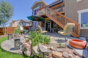 A backyard with a patio, outdoor furniture, a fire pit, and a staircase leading to a deck. - Spacious, Hot Tub, Sauna, Workout Rm, AFA, Schriever, Carson, Olympic Training (Colorado Springs)