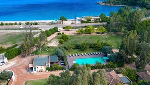 An aerial view of a property with a swimming pool, a tennis court, and a beach in the background. - Cosy apartment for 6 people with WIFI, pool, A/C, TV, terrace and pets allowed (Porto-vecchio)