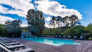 A swimming pool with lounge chairs and tables, surrounded by trees and a clear sky. - Cosy apartment for 6 people with WIFI, pool, A/C, TV, terrace and pets allowed (Porto-vecchio)