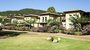 A row of two-story buildings with a garden in front. - Cosy apartment for 6 people with WIFI, pool, A/C, TV, terrace and pets allowed (Porto-vecchio)