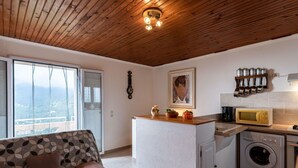 A modern kitchen with a wooden ceiling, a built-in washing machine, and a microwave.