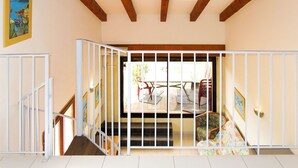 A staircase with white railings leading to a balcony with outdoor seating.