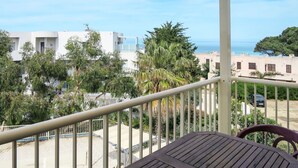 A balcony with a view of a coastal area, including buildings and trees. - Lovely apartment for 4 people with WIFI, pool, A/C, TV, terrace and pets allowed (L'Île-rousse)