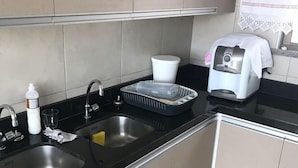 A modern kitchen with a double sink, a toaster, and a dish rack.