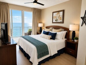 A hotel room with a bed, two bedside lamps, a star decoration, a painting, and a view of the ocean.