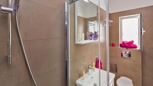 A modern bathroom with a glass shower enclosure, a sink, and a toilet. - Apartments St.Thomas - Deluxe Two-Bedroom Apartment (Dubrovnik)