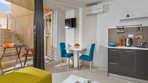 A modern apartment with a dining area, kitchen, and a balcony with a staircase. - Apartments St.Thomas - Deluxe Studio with Terrace (Dubrovnik)