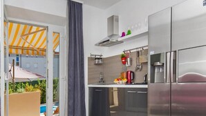 Une cuisine moderne équipée d’appareils électroménagers en acier inoxydable, d’un four encastré et d’un grand réfrigérateur.