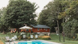 Ein Schwimmbecken mit Liegestühlen und einem Haus im Hintergrund.