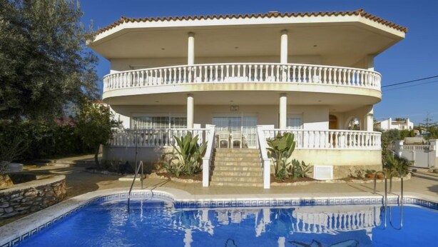 Un bâtiment de deux étages doté d’une piscine ornée d’une fresque représentant un dauphin.