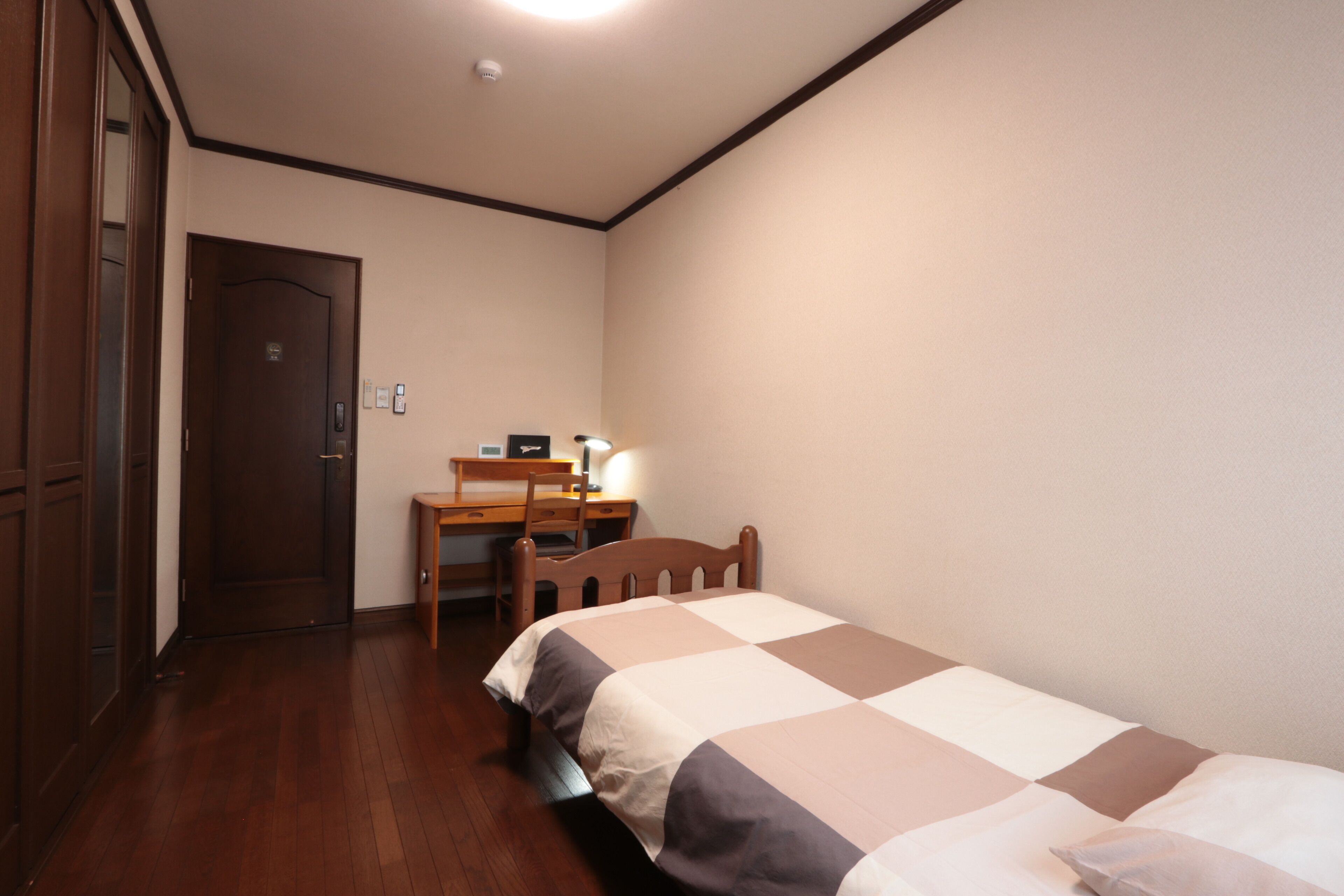 Ein Schlafzimmer mit einem Bett, einem Schreibtisch und einem Stuhl.