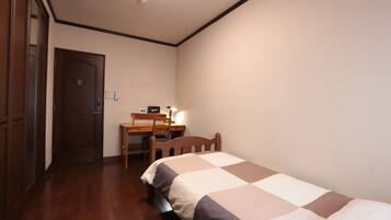 Ein Schlafzimmer mit einem Bett, einem Schreibtisch und einem Stuhl.