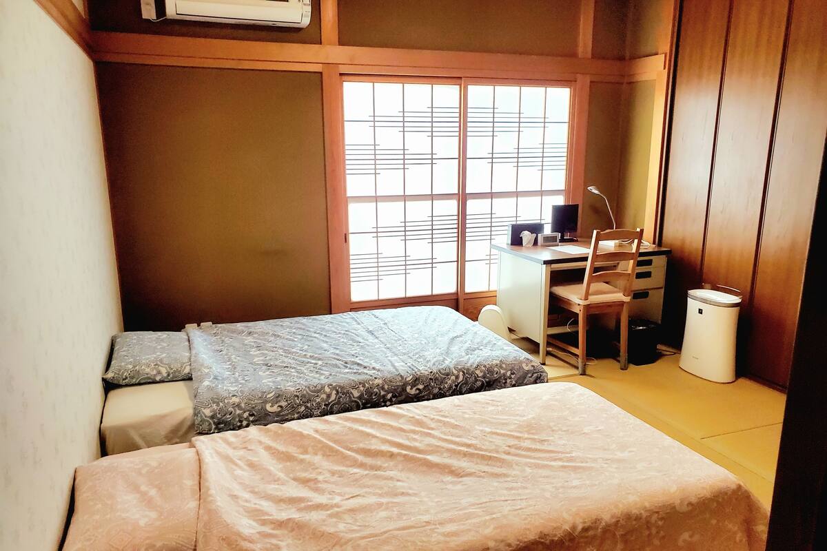 A compact room with a bed, a desk, and a chair.