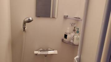 A small, modern bathroom with a shower, a toilet, and a sink.