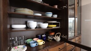 Un armario de madera con repisas que contienen diferentes platos y tazas.