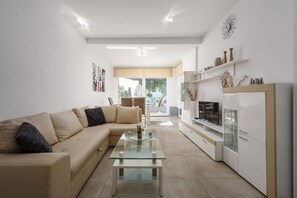 A modern living room with a sofa, coffee table, and built-in TV. - Apartment Monika with private pool in Porec (Kukci)