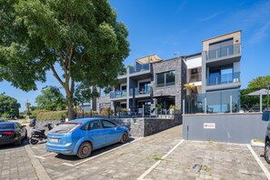 A modern building with a parking area, a tree, and a blue car. - Apartment Monika with private pool in Porec (Kukci)