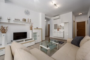 A modern living room with a flat-screen TV, a glass coffee table, and a beige sofa. - Apartment Monika with private pool in Porec (Kukci)