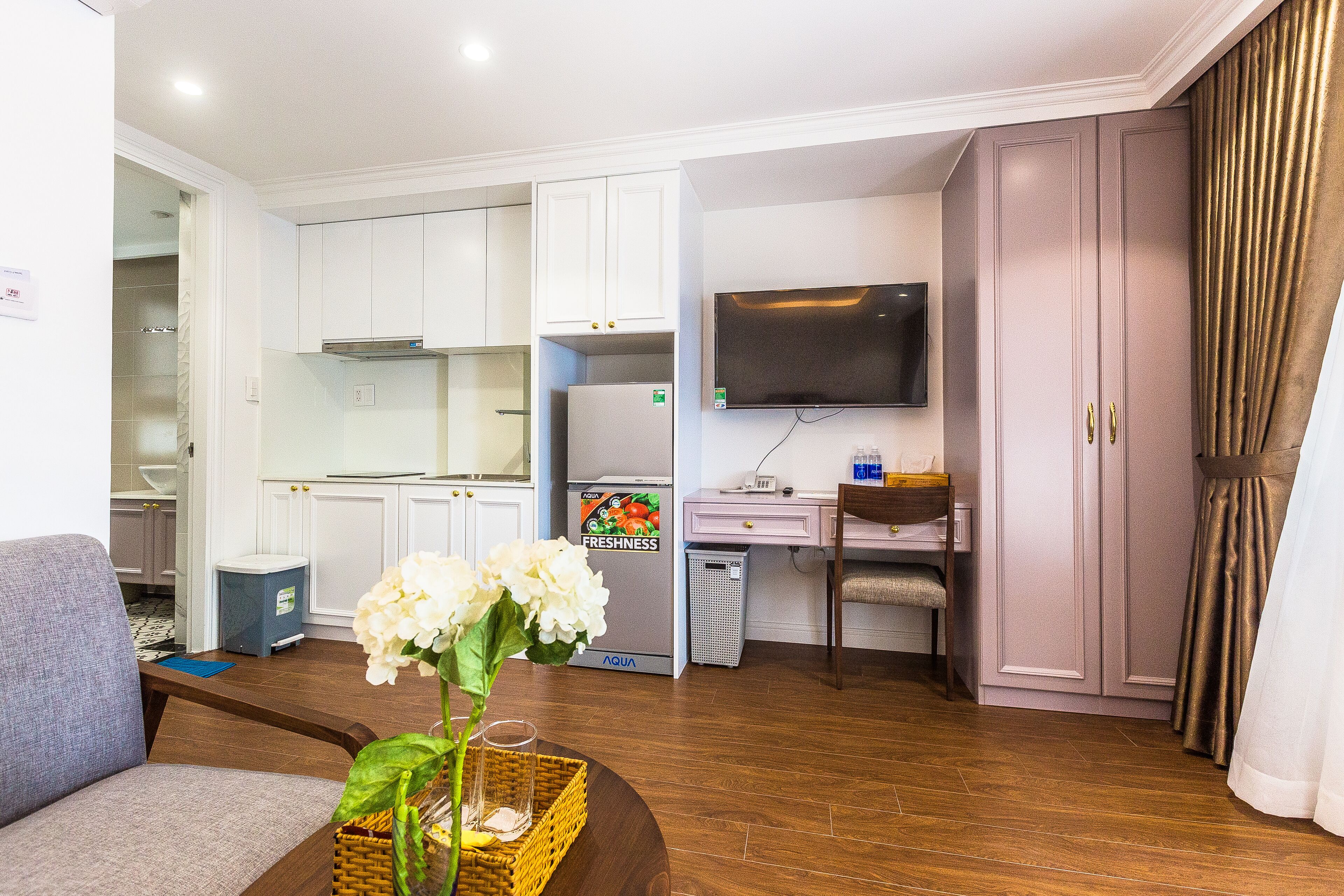 Un espacio habitable compacto con kitchenette, televisor de pantalla plana y comedor.
