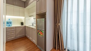 Una cocina moderna con gabinetes grises, un refrigerador de acero inoxidable y un dispensador de agua.