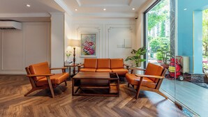 Una sala de estar moderna con sofá de cuero, mesa de centro de madera y sillones a juego.