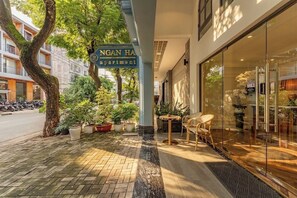 A building with a sign for 'Ngan Ha Apartment' and a glass door entrance.