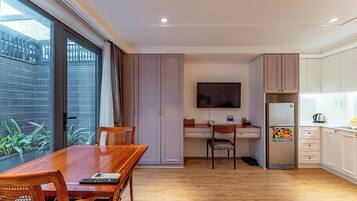 Una cocina moderna con comedor, televisor de pantalla plana y refrigerador.